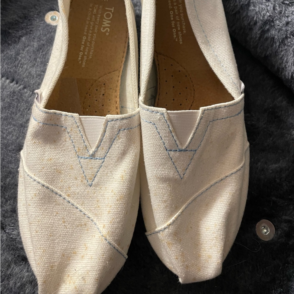 Classic TOMS slip on in white with yellow accents. Worn one time. 8M